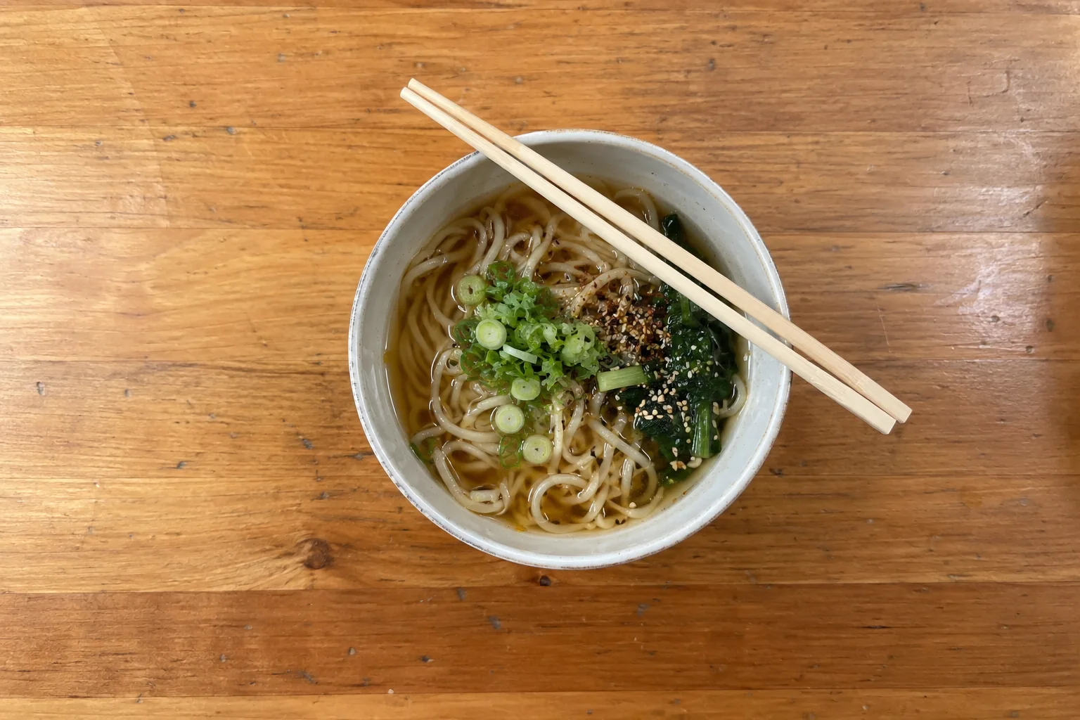 A bowl of noodles with chopsticks on a timber counter in the C Concourse at Seattle-Tacoma airport.