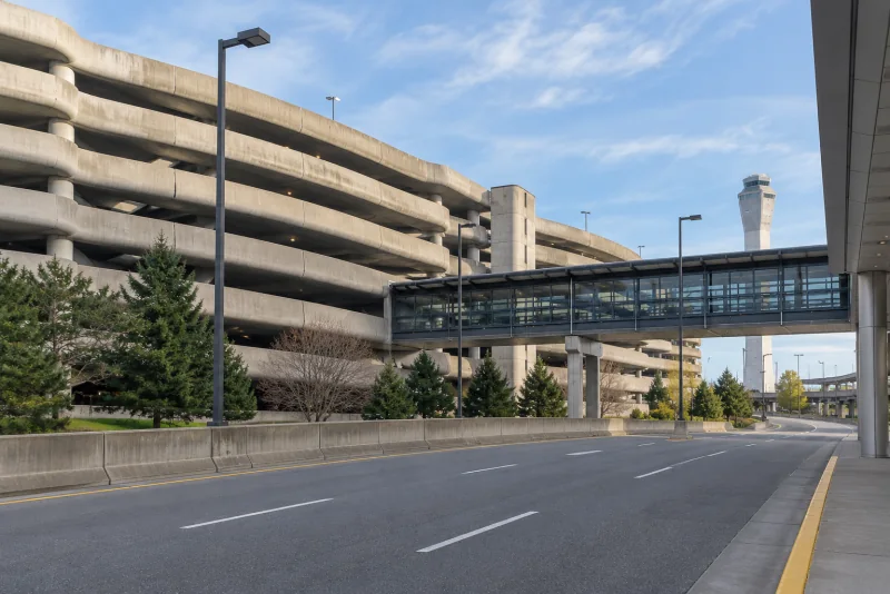 The curved concrete parking garage and covered skybridge at Seattle-Tacoma airport seen from the roadway.