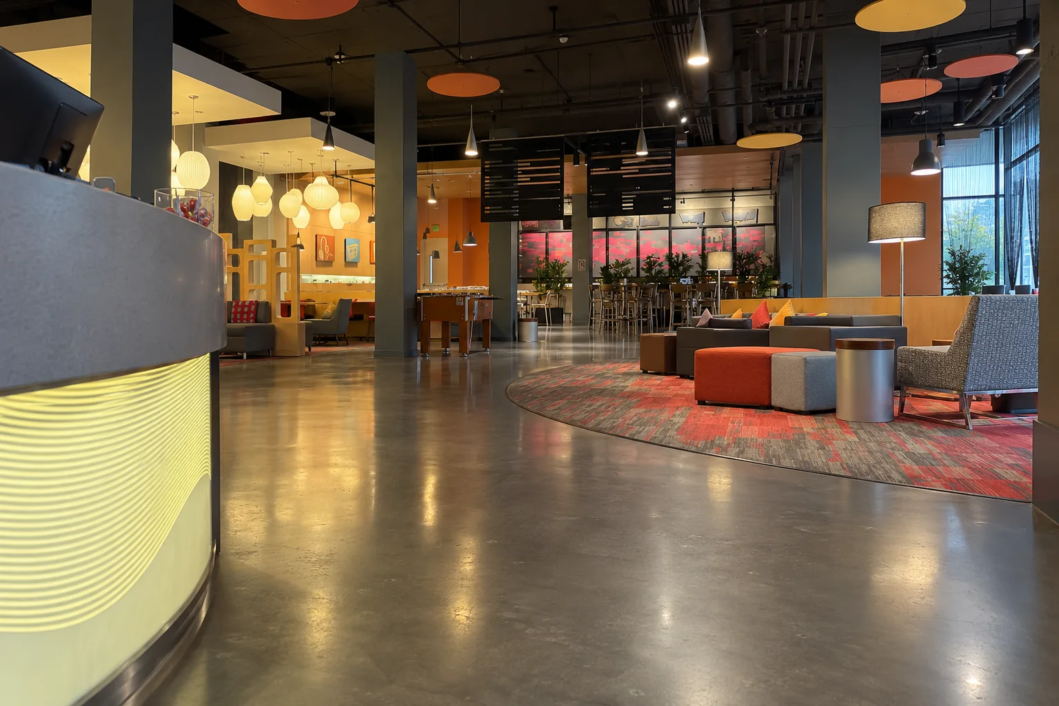 A hotel lobby near Seattle-Tacoma airport with a round front desk, acoustic discs and a red patterned rug.