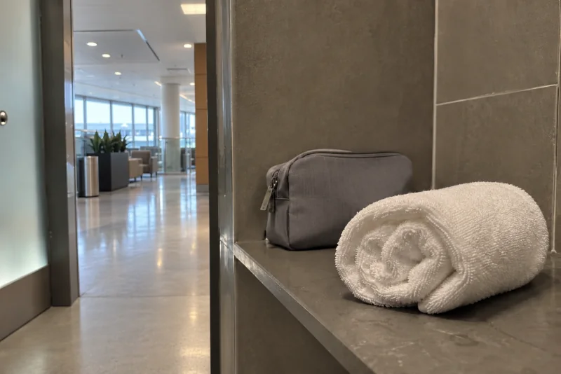 A rolled white towel and a small toiletry bag on a shelf at Seattle-Tacoma airport.