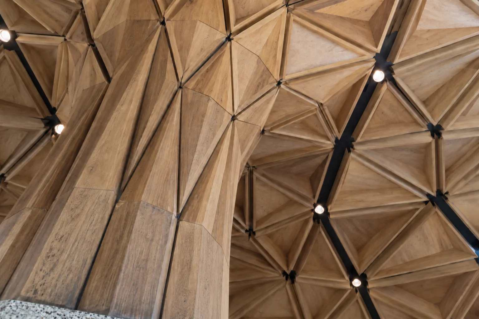 The branching timber column flaring into the faceted timber ceiling of the Central Terminal at Seattle-Tacoma airport.