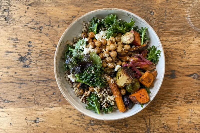 A grain bowl of greens, roasted vegetables and chickpeas on a timber table at Seattle-Tacoma airport.