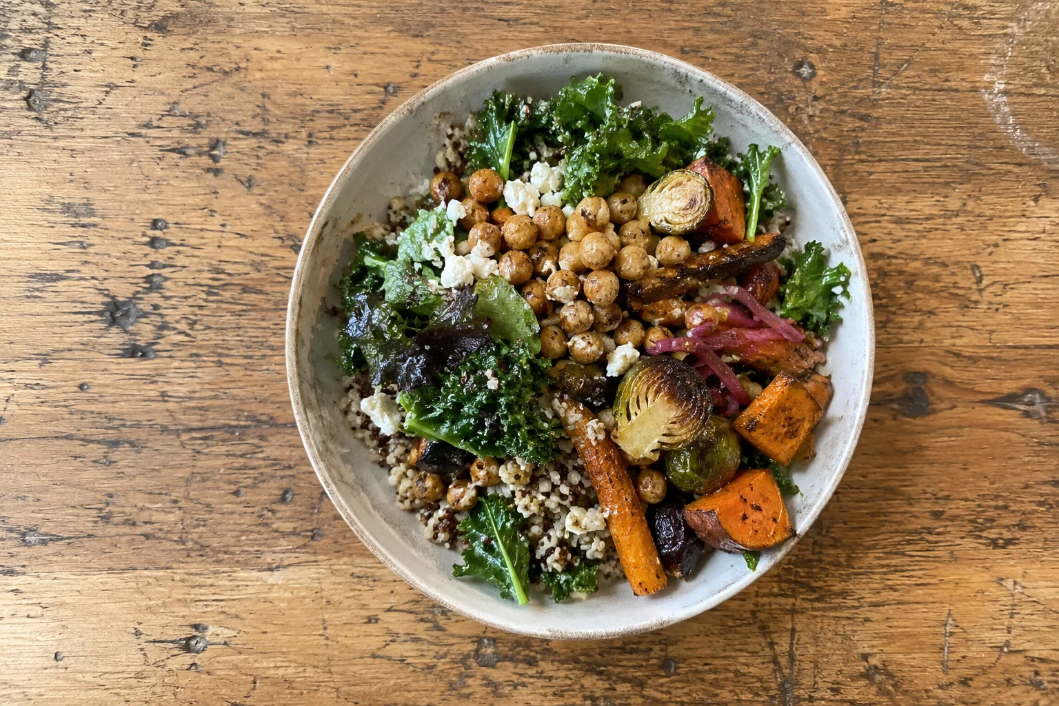 A grain bowl of greens, roasted vegetables and chickpeas on a timber table at Seattle-Tacoma airport.