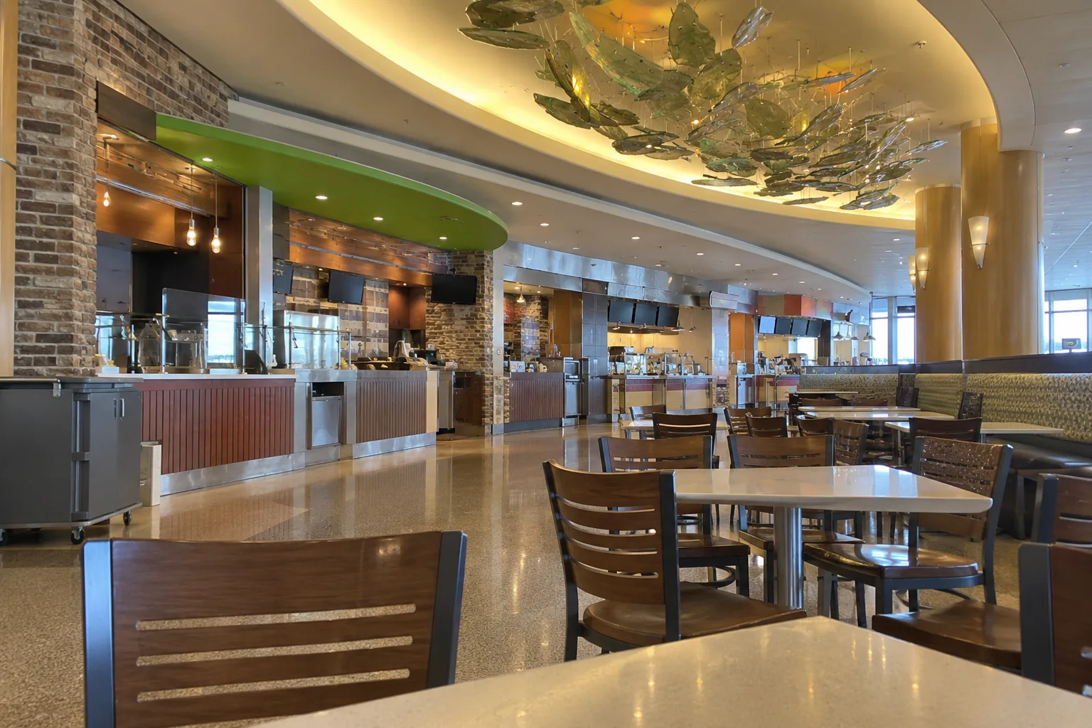 A concourse food court seen from the tables, with counter restaurants and a curved ceiling.