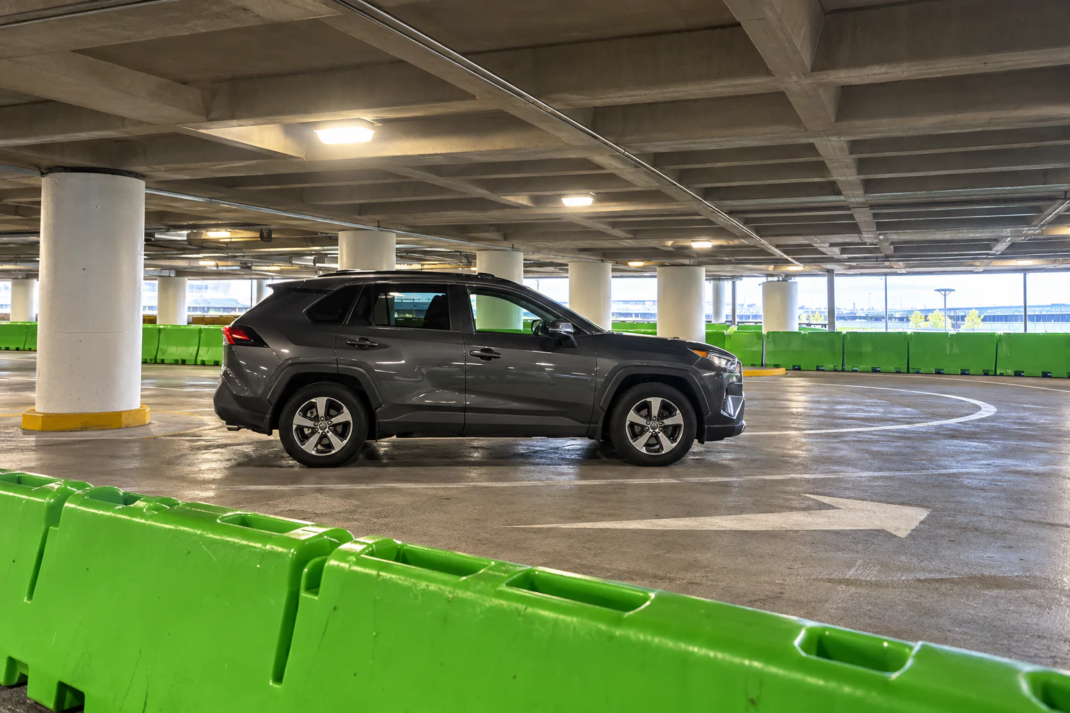 A rideshare vehicle beside the green pickup barriers in SEA’s Level 3 garage