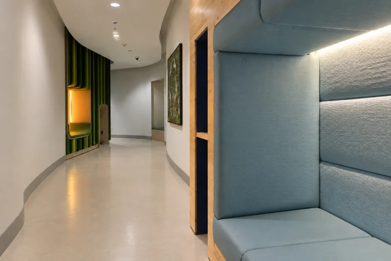 A corridor in the sensory room at Seattle-Tacoma airport with a padded blue-grey nook and a green felt alcove.