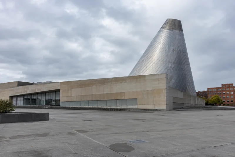 The Museum of Glass in Tacoma with its slanted steel cone, seen across the plaza.