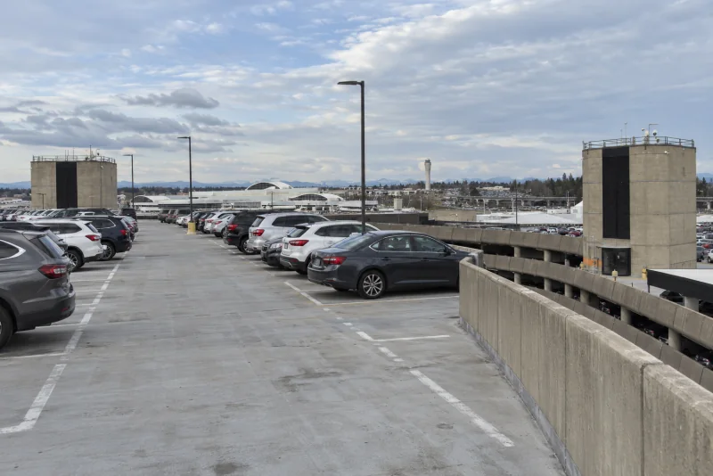The open top deck of the Seattle-Tacoma airport parking garage with rows of parked cars.